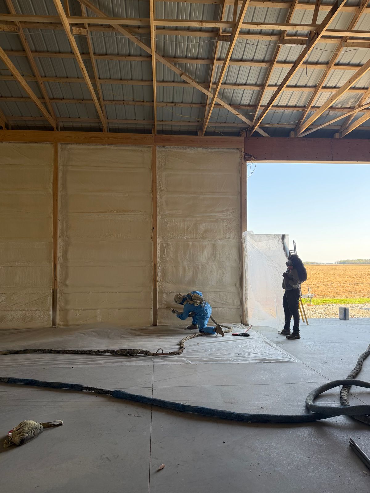 Our crew spraying the walls, with the floor covered in plastic.
