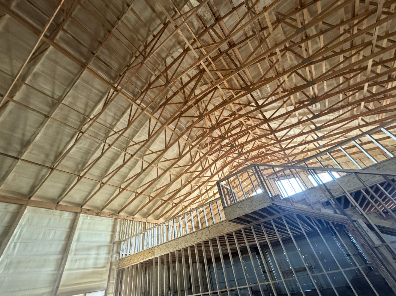 Roof trusses and loft framing, with foam on the roof above.